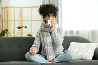 Cold symptom. Young woman with tissue at home