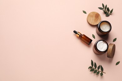 Photo of Different cosmetic products and leaves on beige background, flat lay. Space for text