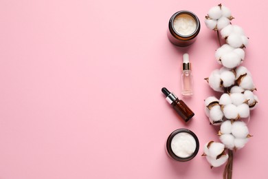 Photo of Different cosmetic products and cotton flowers on pink background, flat lay. Space for text