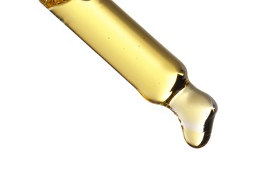 Essential oil dripping from pipette against white background