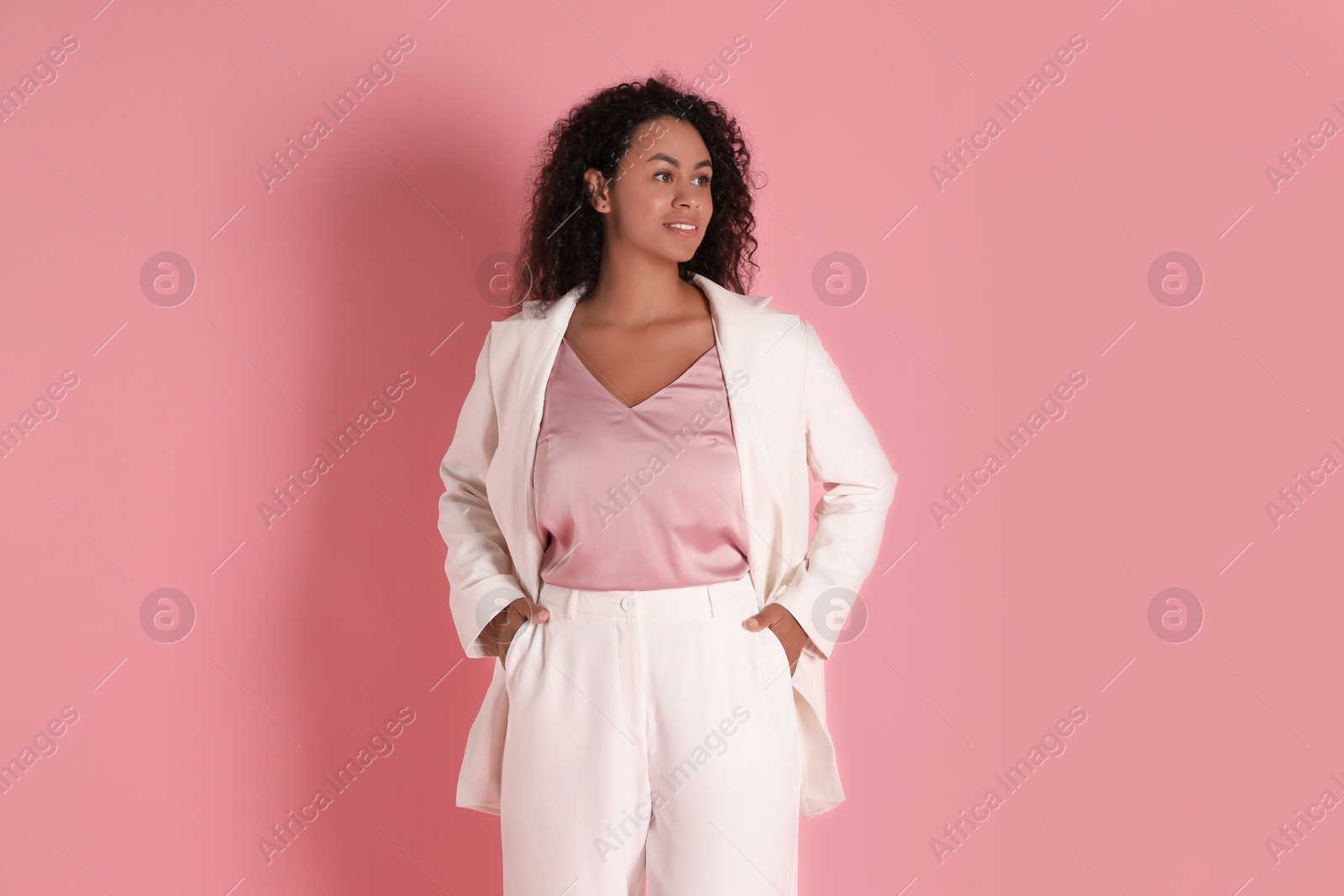 Photo of Beautiful woman in stylish suit on pink background