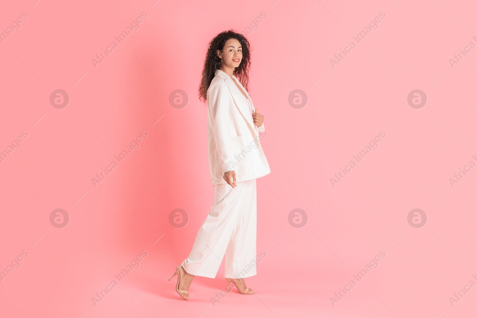 Photo of Beautiful woman in stylish suit on pink background