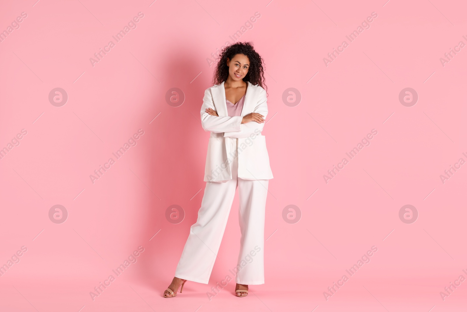 Photo of Beautiful woman in stylish suit on pink background