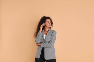 Beautiful woman in stylish jacket on beige background