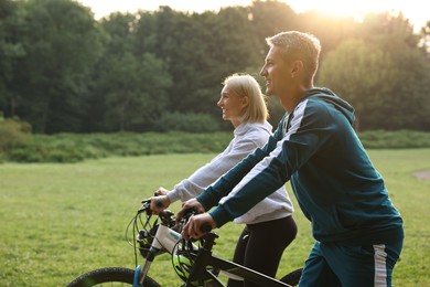 Photo of Happy couple riding bicycles in park. Healthy lifestyle