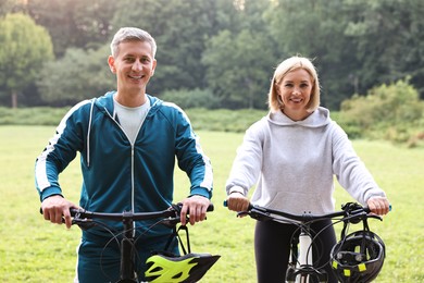 Happy couple with bicycles in park. Healthy lifestyle