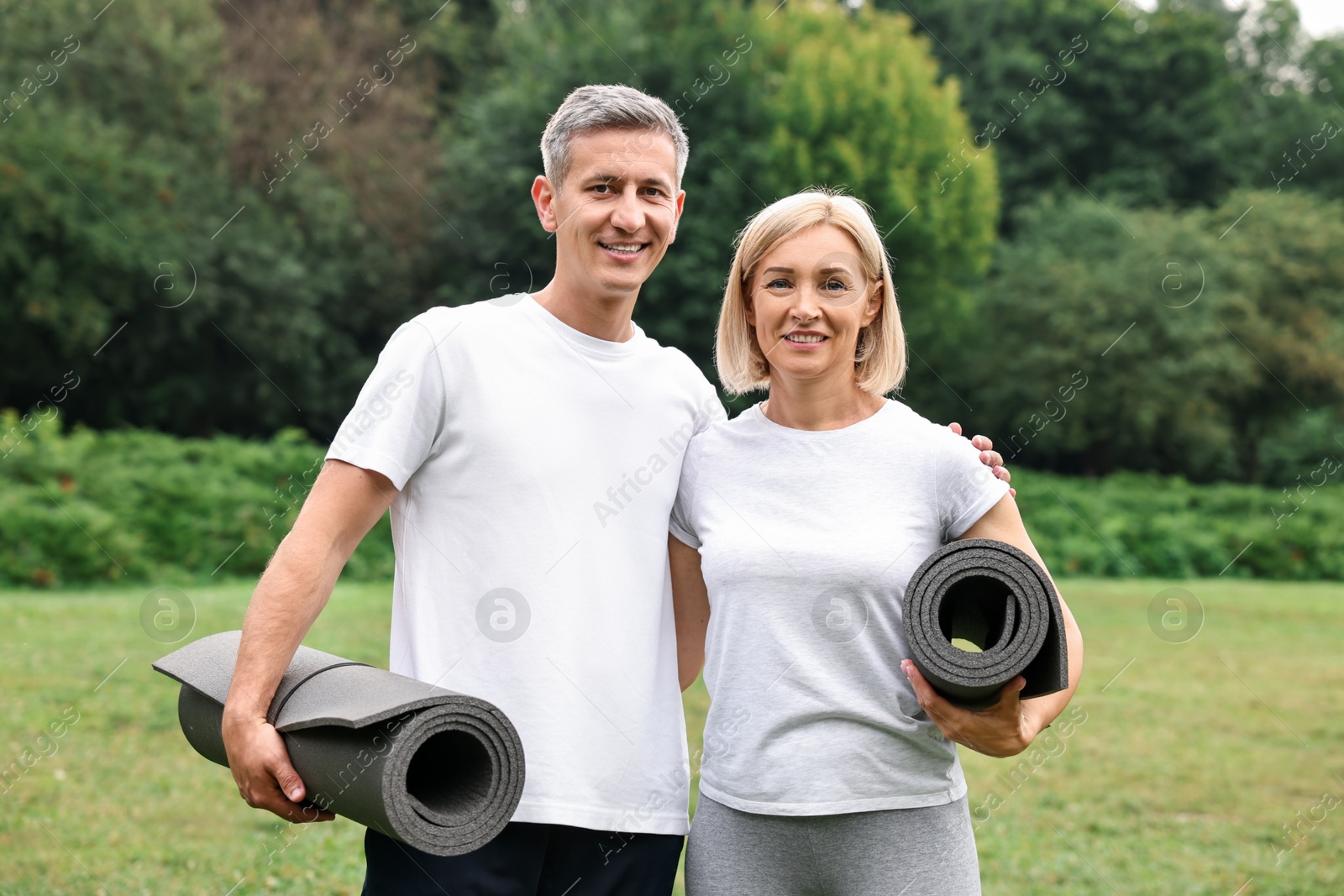 Photo of Happy couple with yoga mats in park