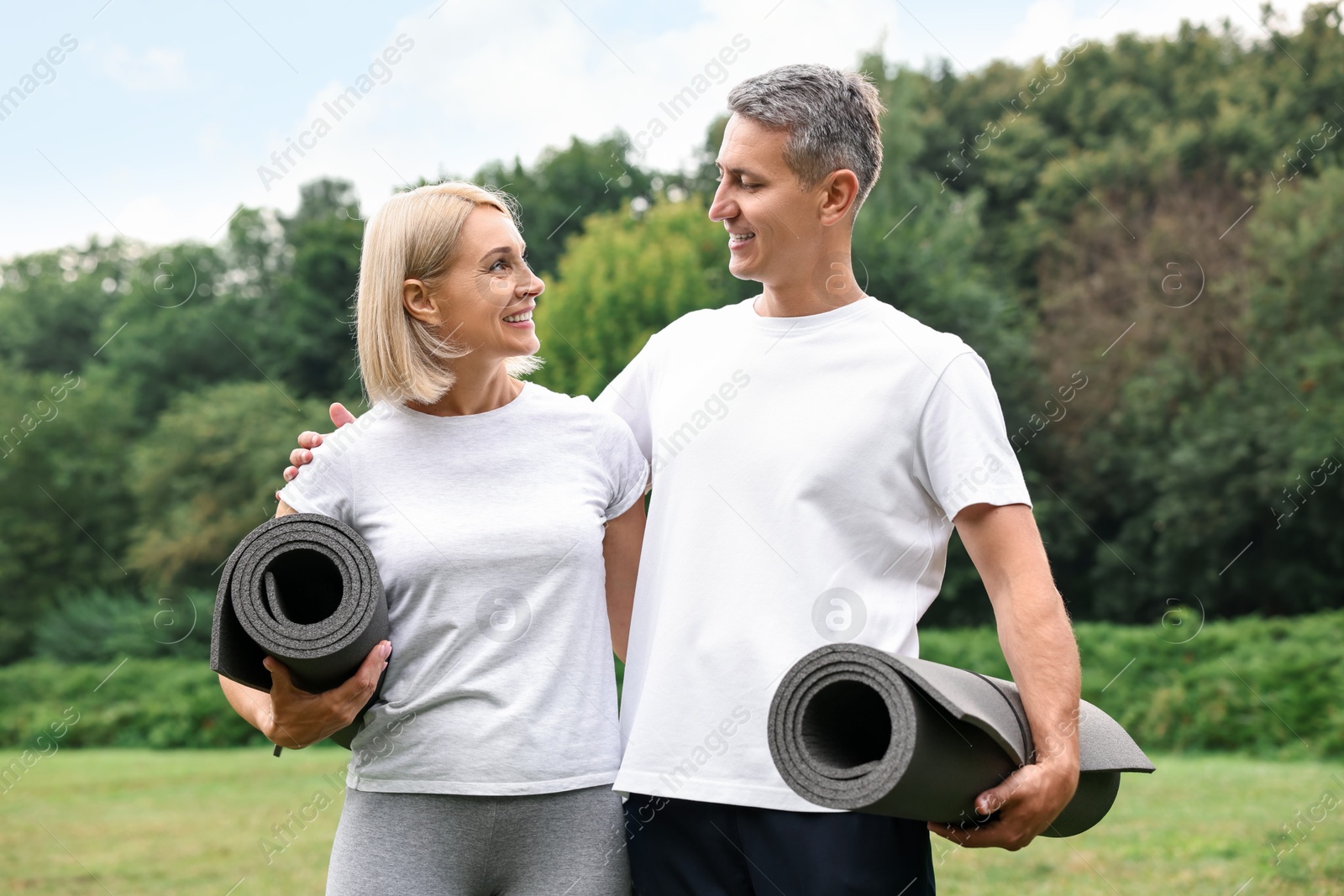 Photo of Happy couple with yoga mats in park