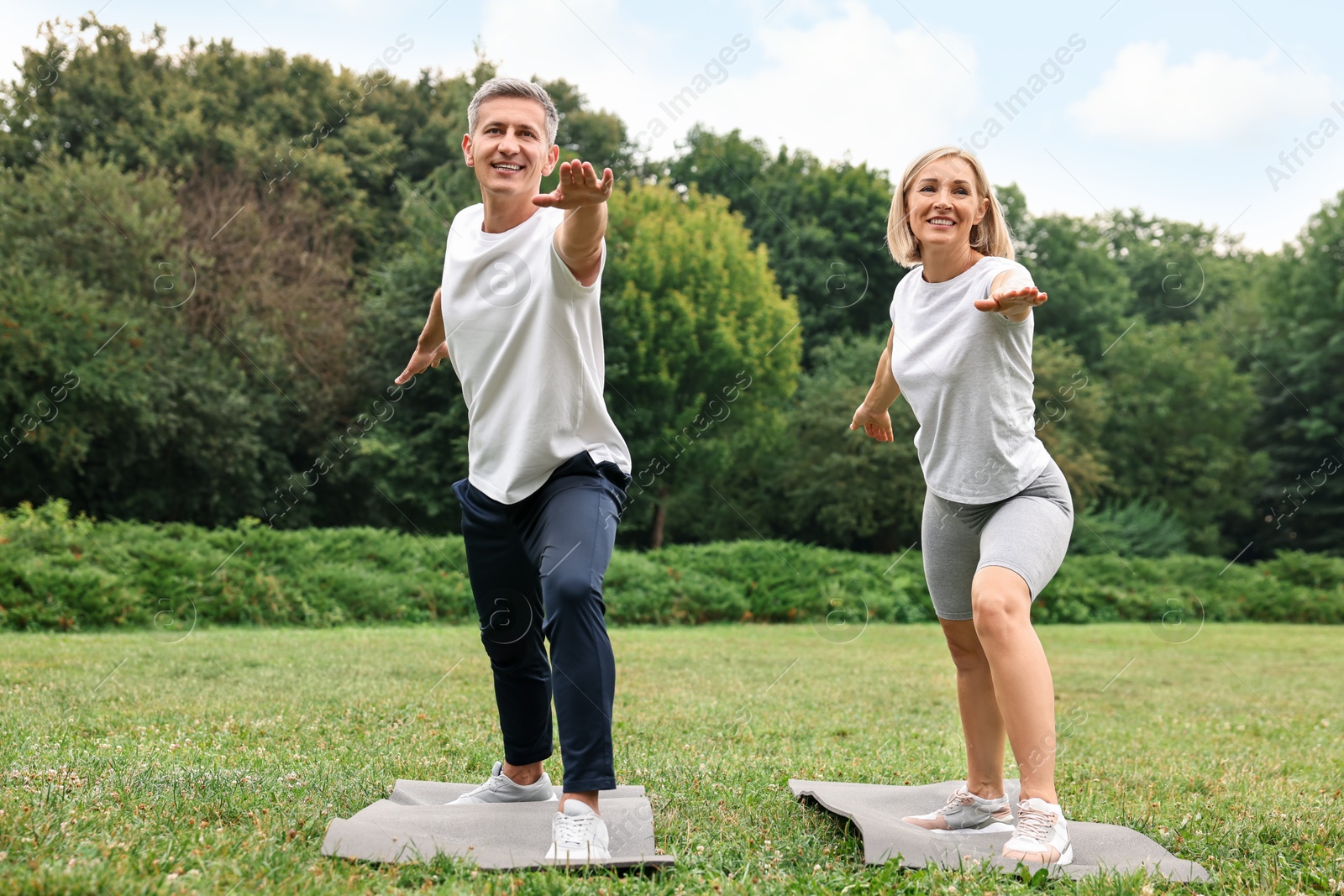 Photo of Happy couple doing exercises in park. Healthy lifestyle