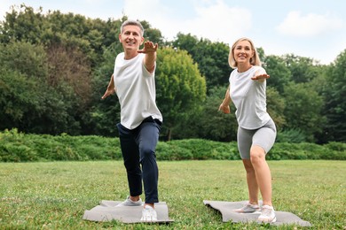 Photo of Happy couple doing exercises in park. Healthy lifestyle