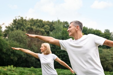 Photo of Happy couple doing exercises in park. Healthy lifestyle