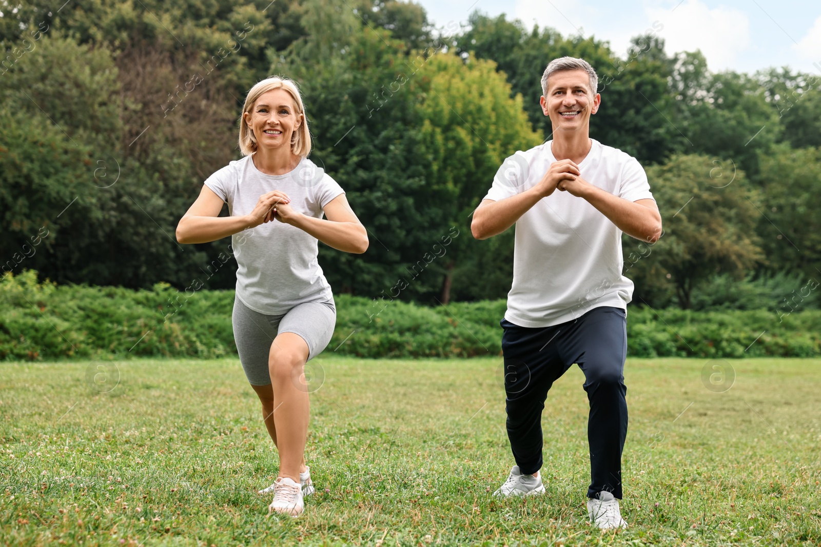 Photo of Happy couple doing exercises in park. Healthy lifestyle