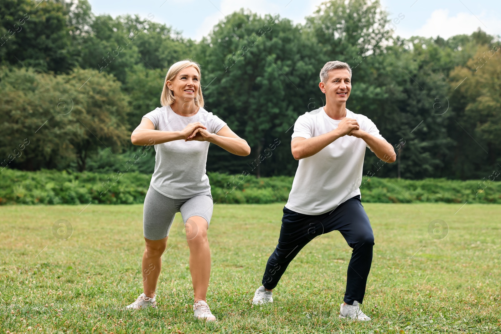 Photo of Happy couple doing exercises in park. Healthy lifestyle