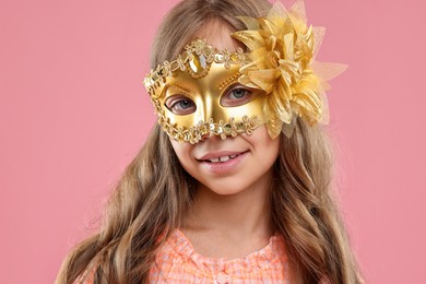 Photo of Cute girl wearing carnival mask on pink background