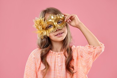 Photo of Cute girl wearing carnival mask on pink background