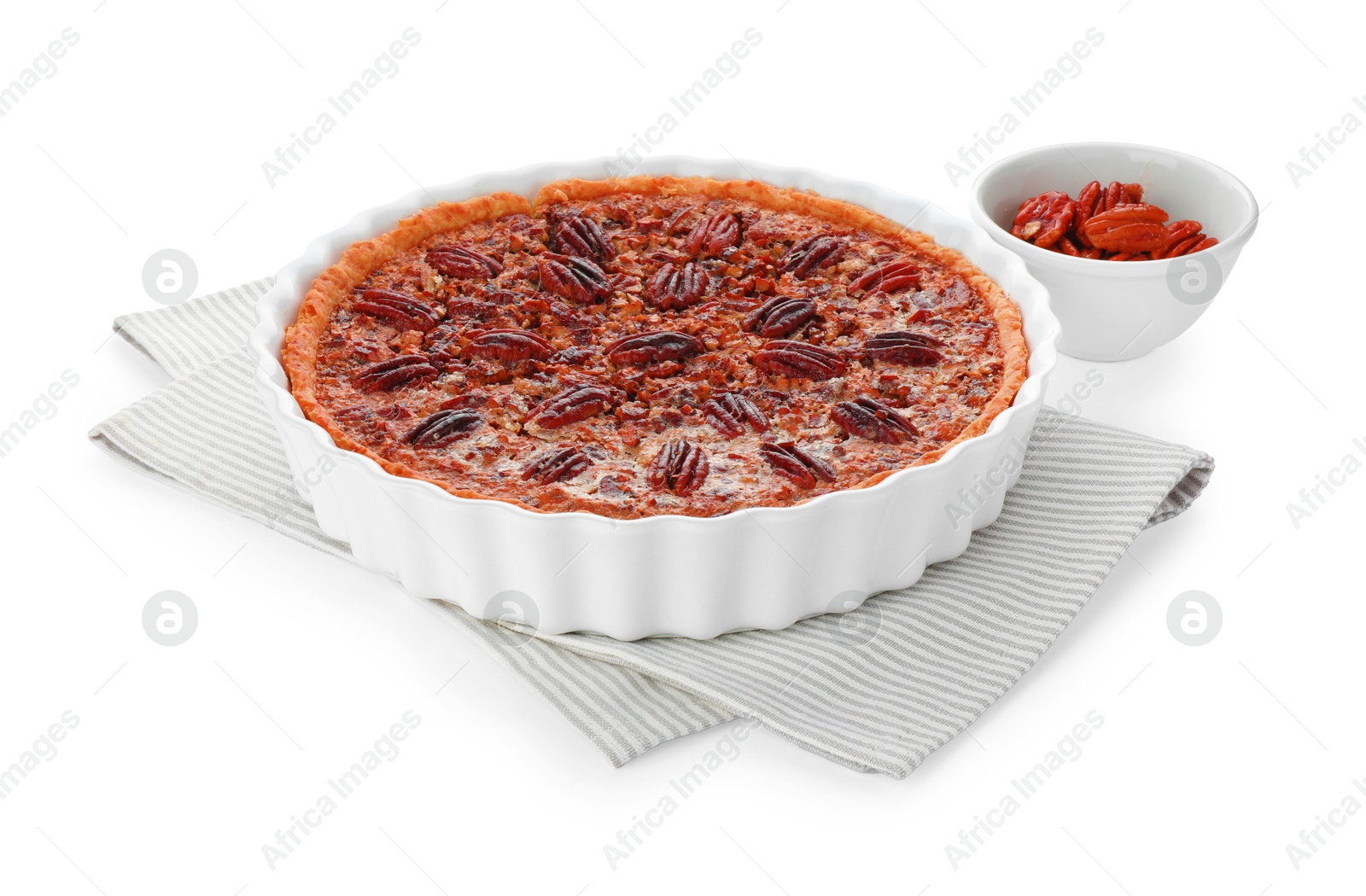 Photo of Delicious pecan pie in baking dish and bowl with fresh nuts isolated on white