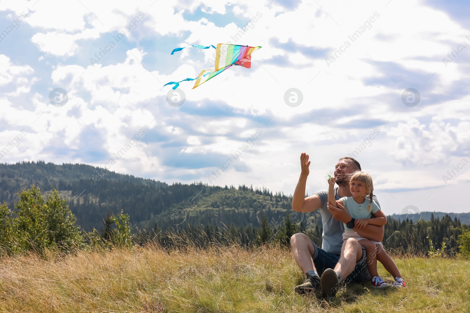 Photo of Father with daughter flying kite at field