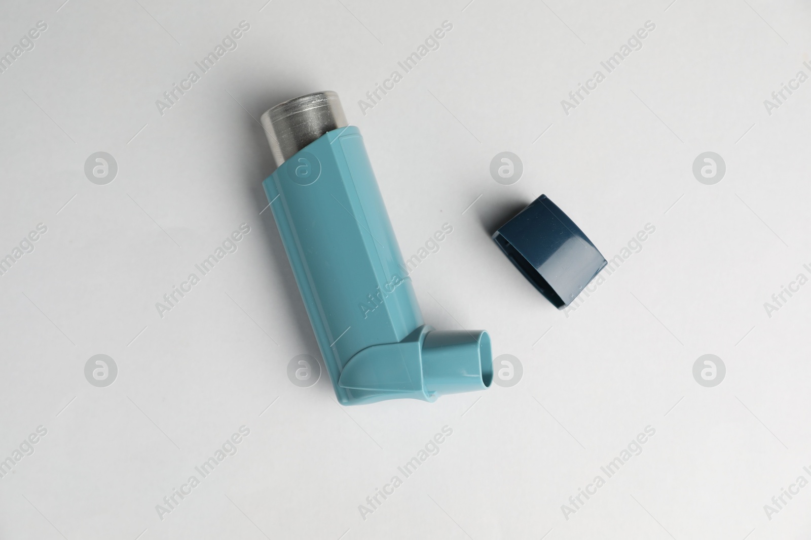 Photo of Asthma inhaler on light grey background, top view