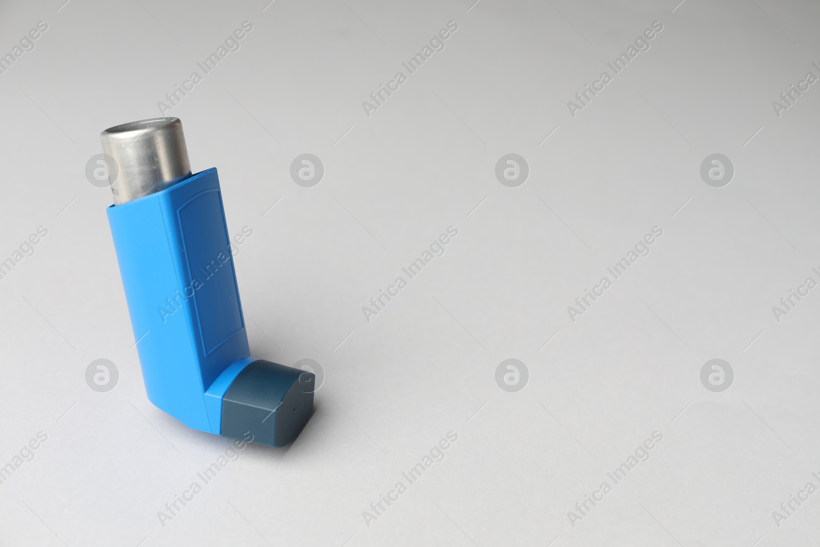 Photo of Asthma inhaler on light grey background, space for text