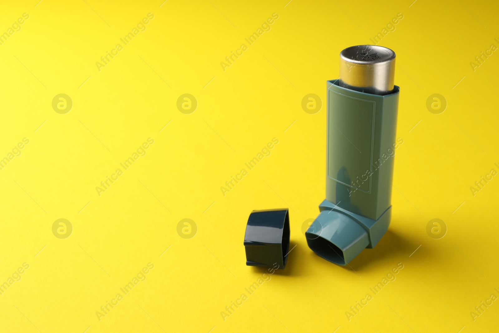 Photo of Asthma inhaler on yellow background, space for text