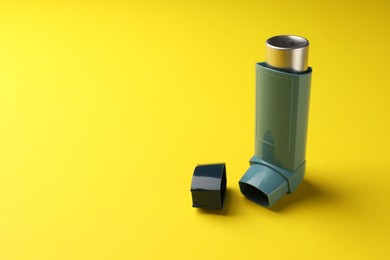 Photo of Asthma inhaler on yellow background, space for text