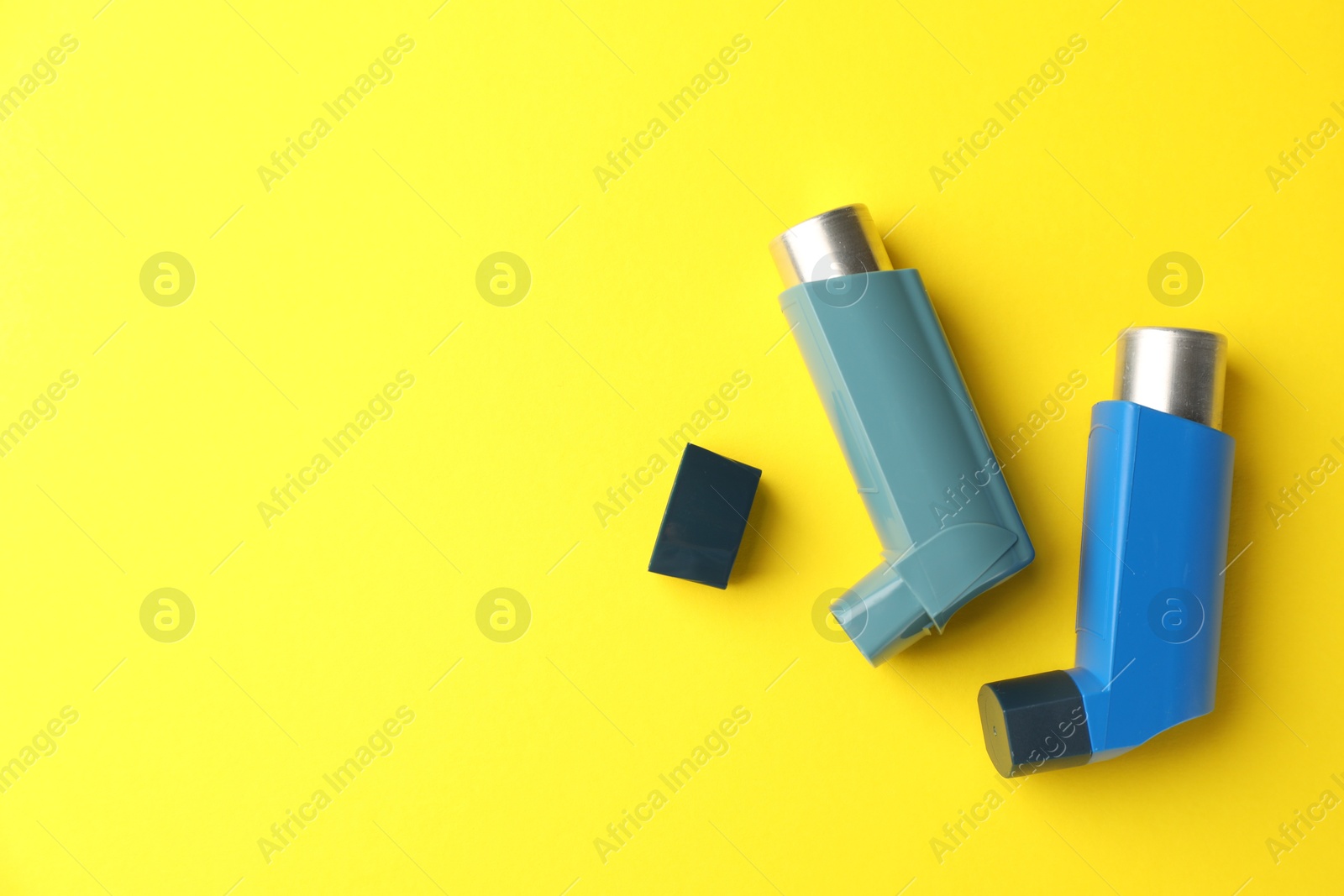 Photo of Asthma inhaler on yellow background, top view. Space for text