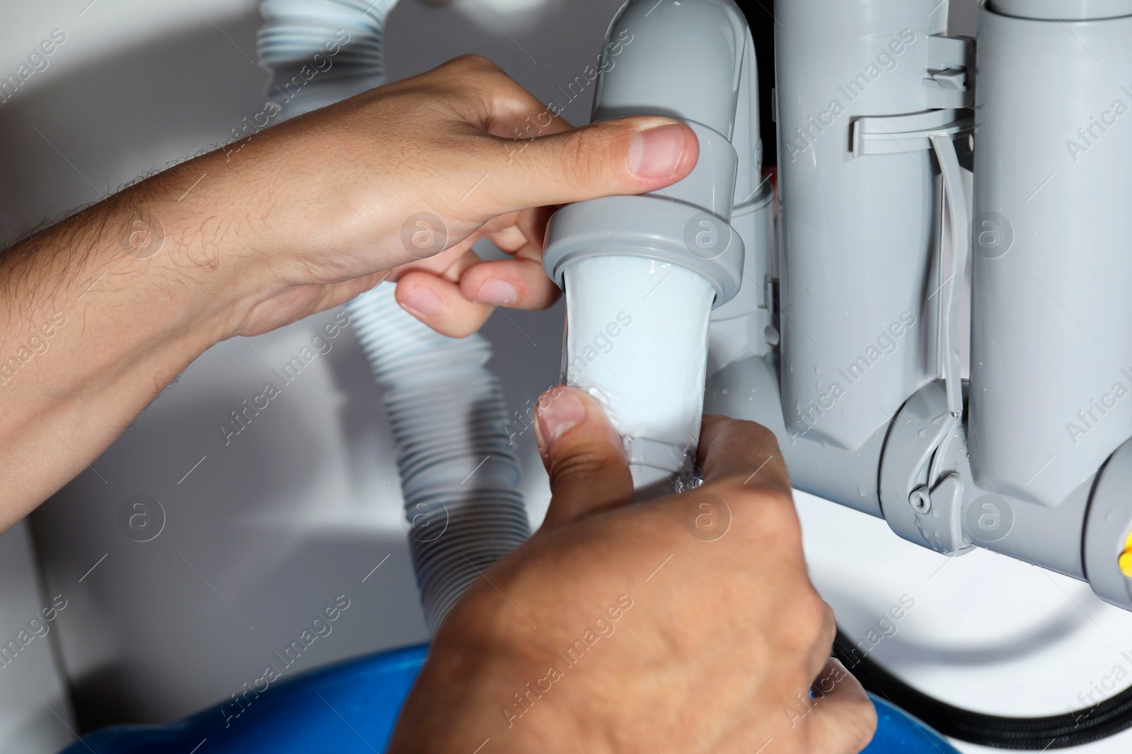 Photo of Professional plumber fixing piping system at home, closeup