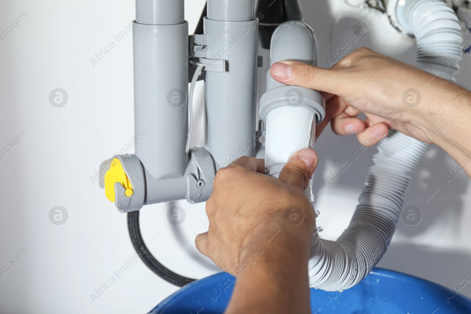 Photo of Professional plumber fixing piping system at home, closeup