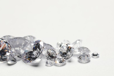 Photo of Many beautiful shiny diamonds on white background, closeup. Space for text