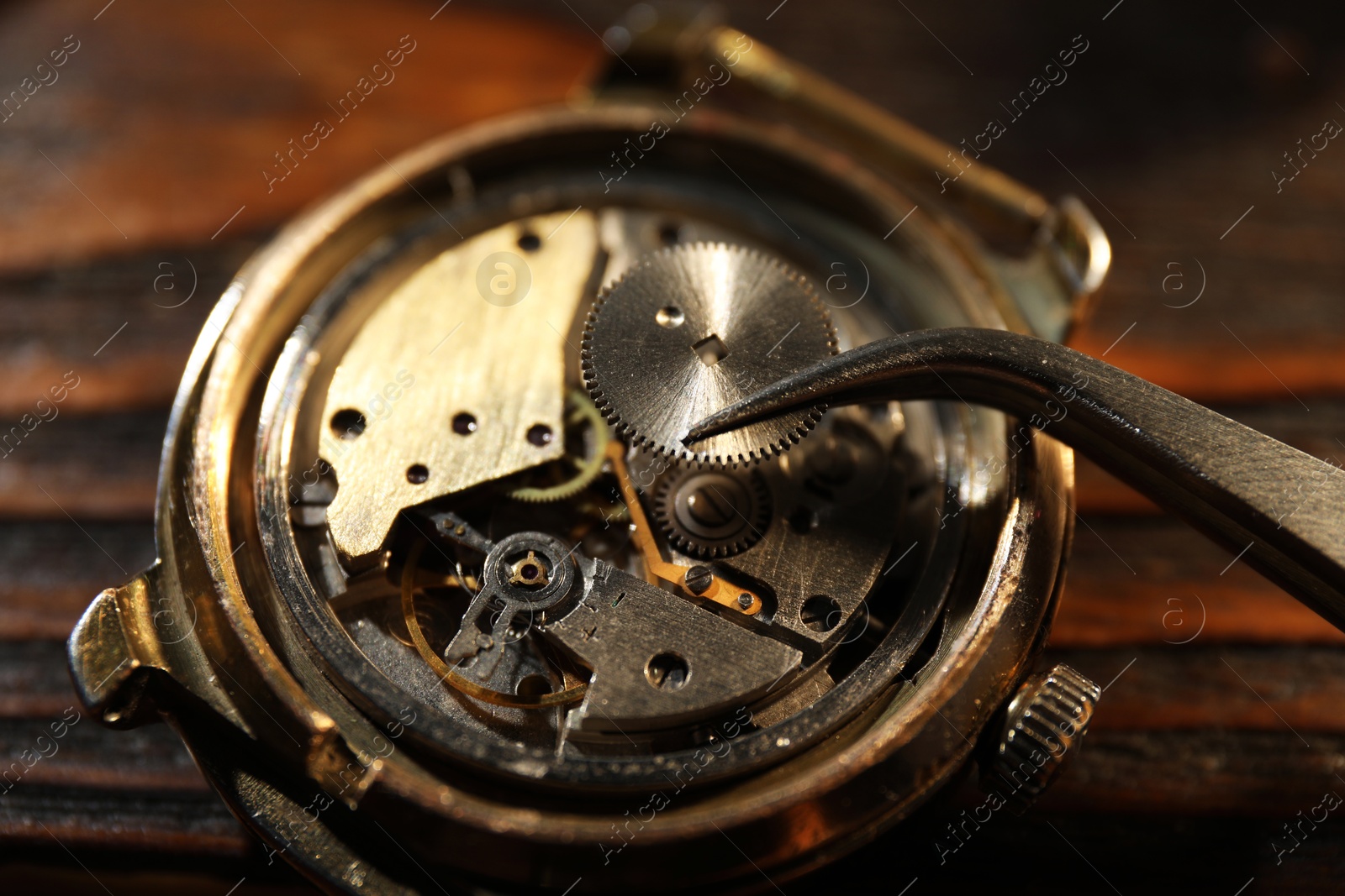 Photo of Mechanism of vintage wrist watch and tool on table, closeup