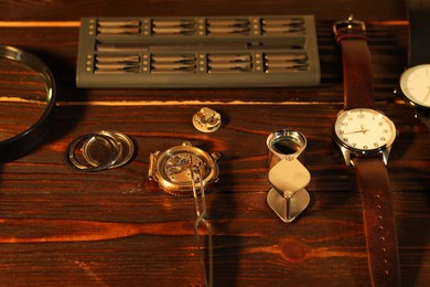 Mechanism of vintage wrist watch and tool on wooden table