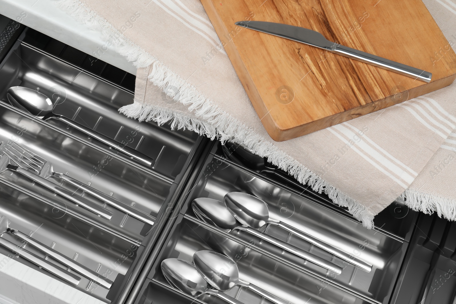 Photo of Box with cutlery in drawer, above view. Kitchen utensils storage