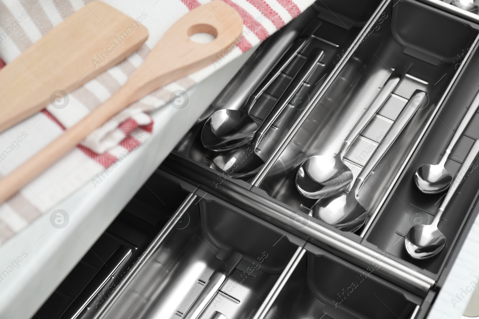 Photo of Box with cutlery in drawer, closeup. Kitchen utensils storage