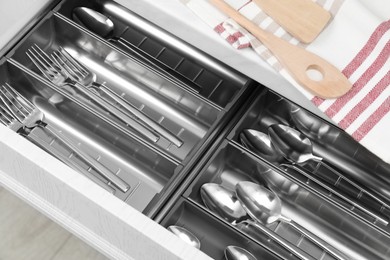 Photo of Box with cutlery in drawer, above view. Kitchen utensils storage