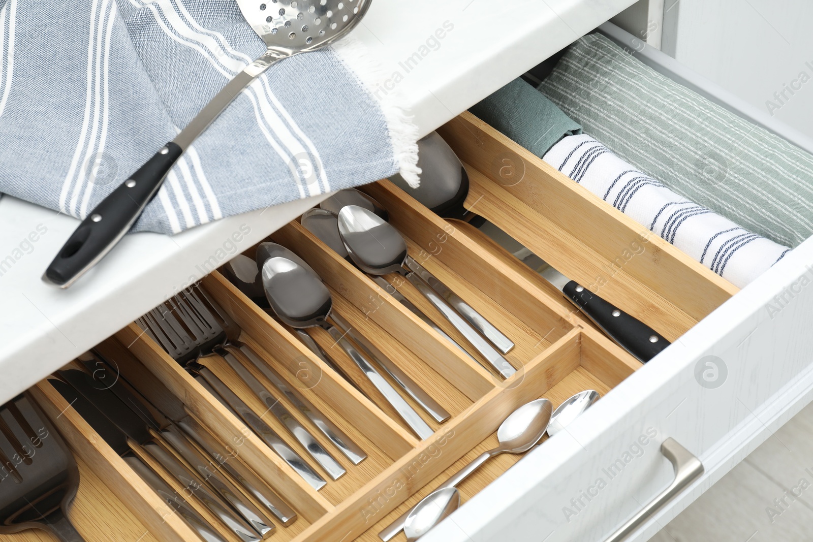 Photo of Box with cutlery in drawer, closeup. Kitchen utensils storage