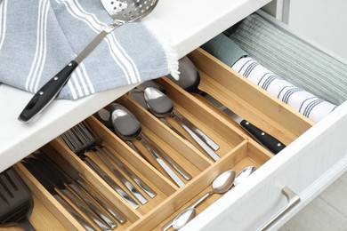 Photo of Box with cutlery in drawer, closeup. Kitchen utensils storage