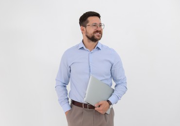 Portrait of smiling businessman with laptop on white background