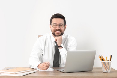 Photo of Portrait of smiling businessman at table against white background