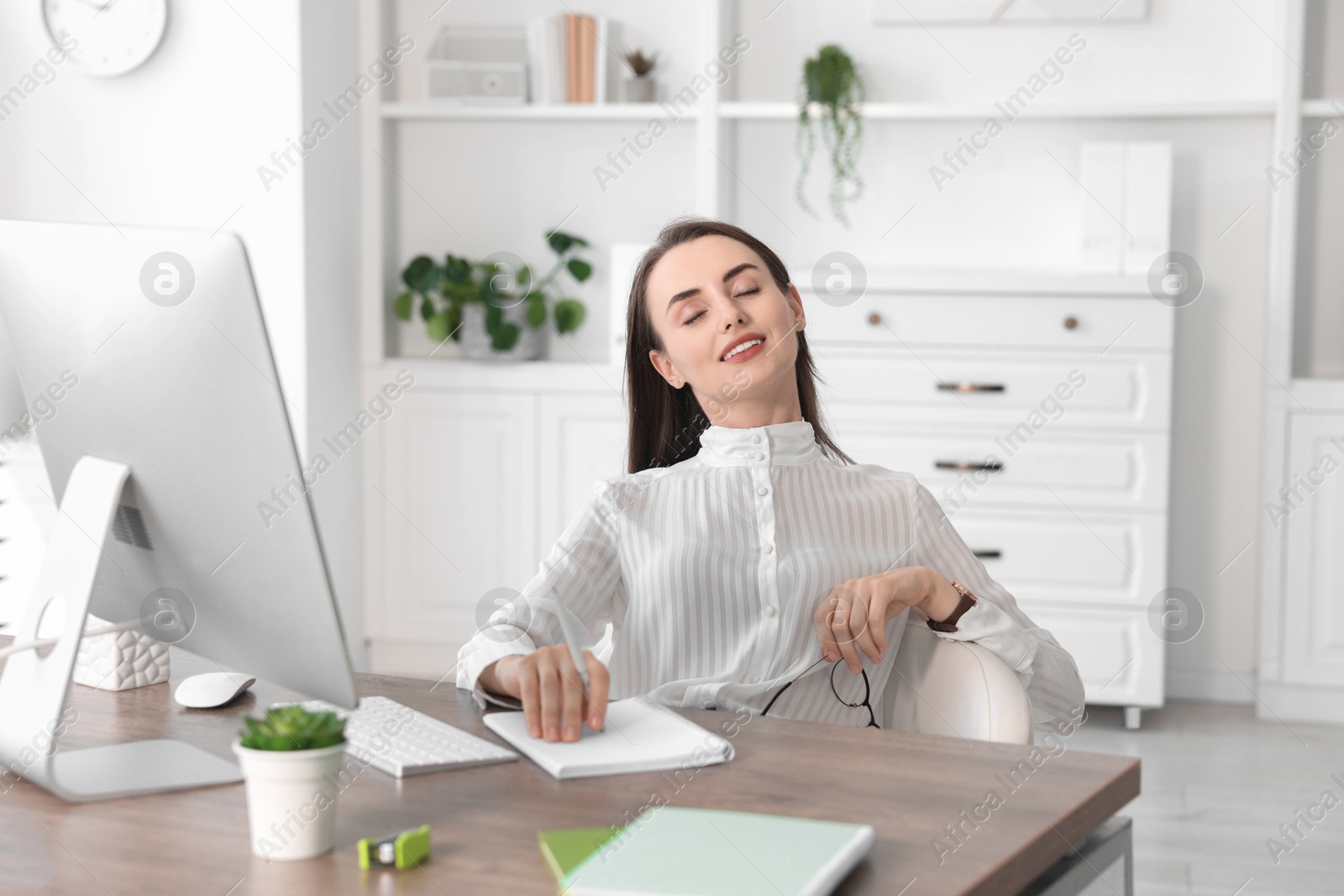 Photo of Beautiful businesswoman relaxing at table in office. Break time