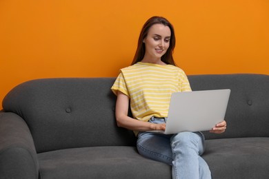 Photo of Smiling woman with laptop on sofa at home