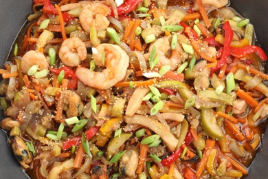 Photo of Stir-fry sea food in wok, top view