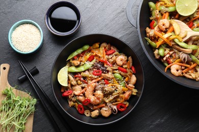 Stir-fry sea food served on grey textured table, flat lay