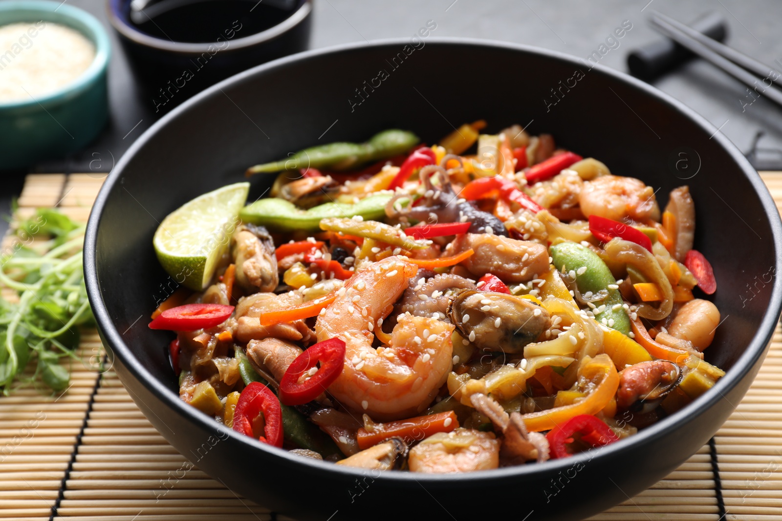 Photo of Stir-fry sea food served on grey table, closeup