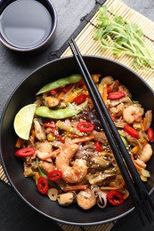 Photo of Stir-fry sea food served on grey textured table, flat lay