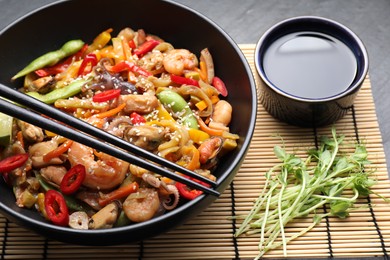 Photo of Stir-fry sea food served on grey table, closeup