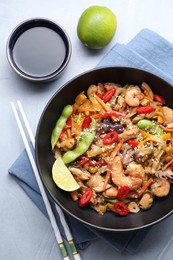 Photo of Stir-fry sea food served on light grey table, flat lay