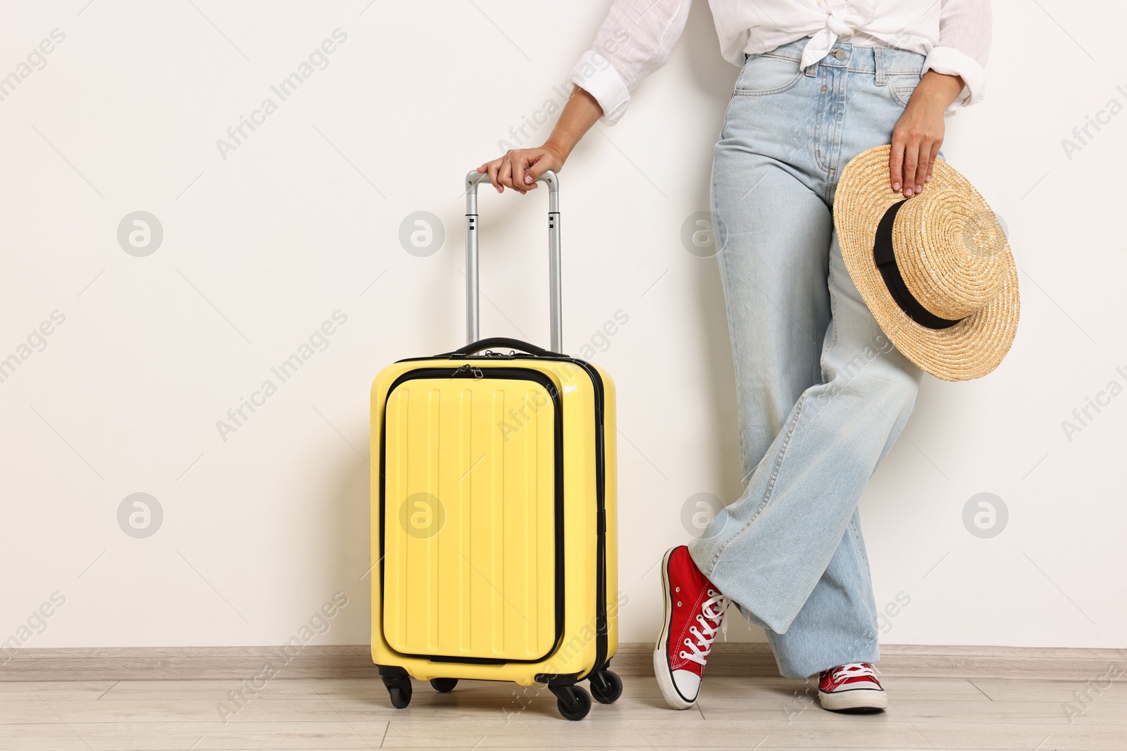 Photo of Woman with suitcase and straw hat indoors, closeup