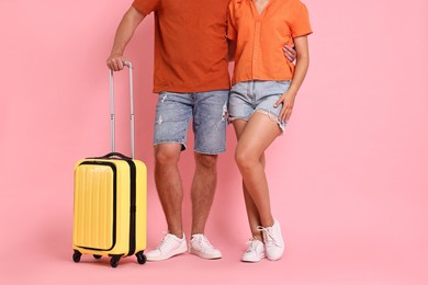 Woman and man with suitcase on pink background, closeup