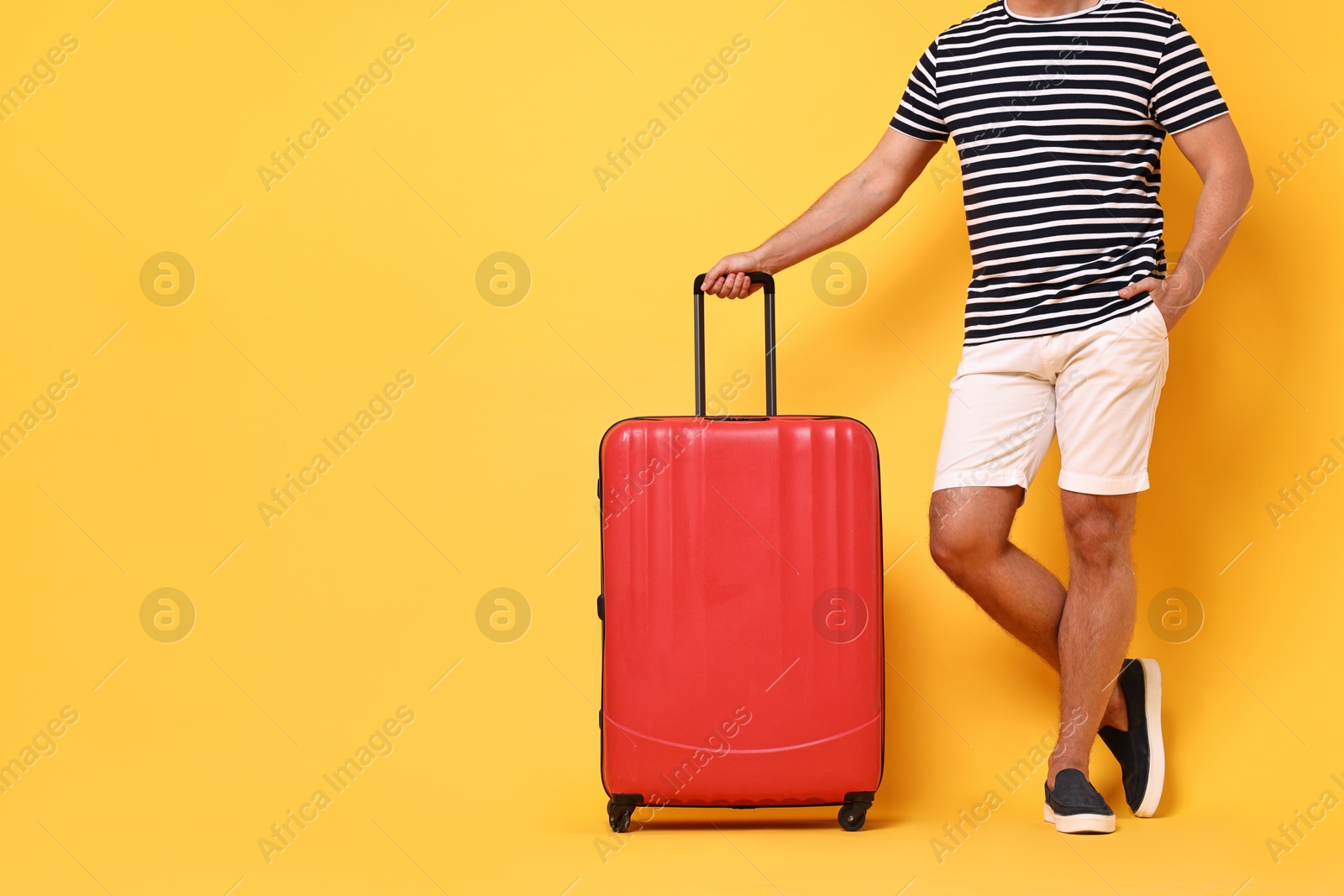 Photo of Man with suitcase on orange background, closeup. Space for text