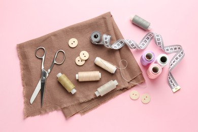 Photo of Flat lay composition with different sewing supplies on pink background